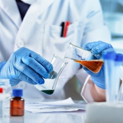 Scientist mixing chemical liquids in the chemistry lab. Researcher working whit fluids in flasks in the chemical laboratory